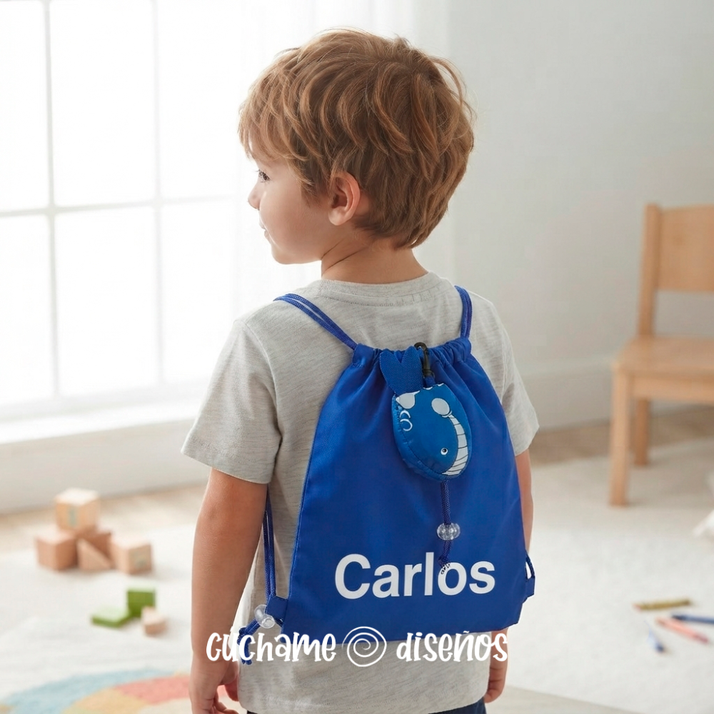 Niño llevando mochila de cuerdas azul con bolsillo de pez y nombre personalizado